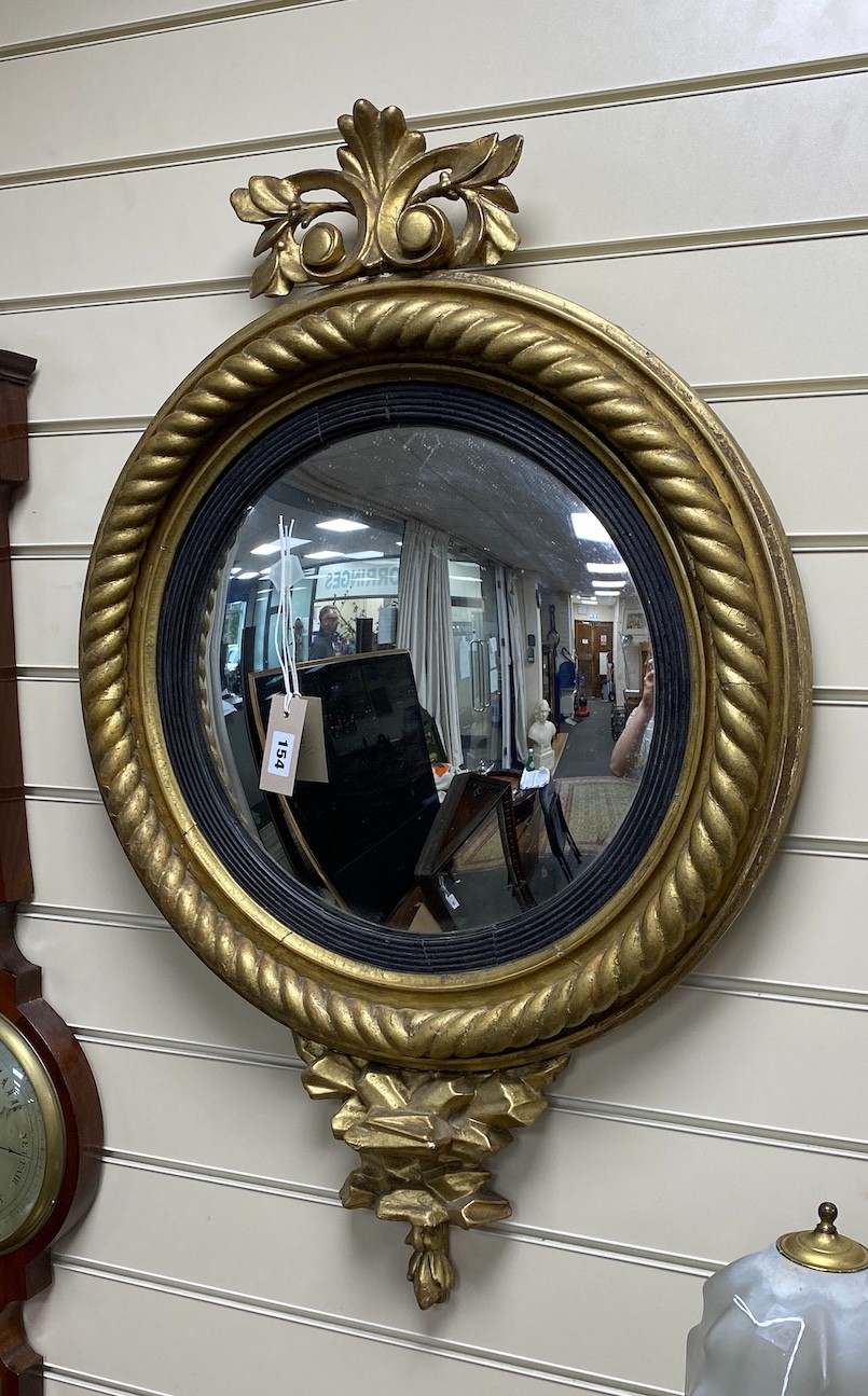 A Regency carved giltwood convex wall mirror, diameter 56cm, height 85cm